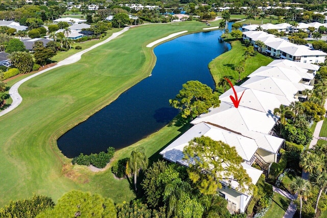 drone / aerial view featuring golf course view, a water view, and a residential view