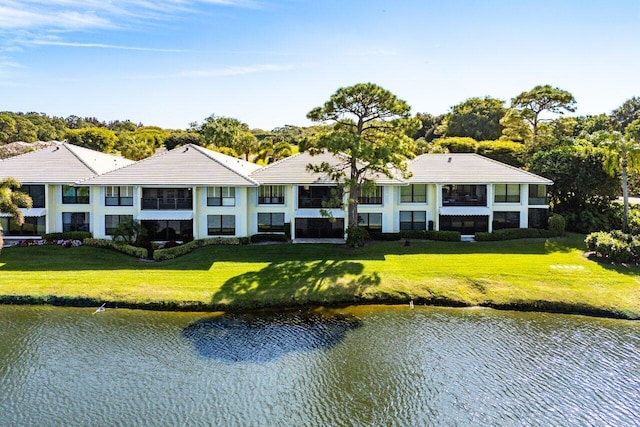 back of property with a yard and a water view