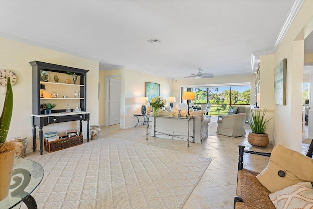 living area with light tile patterned floors, a ceiling fan, visible vents, and crown molding