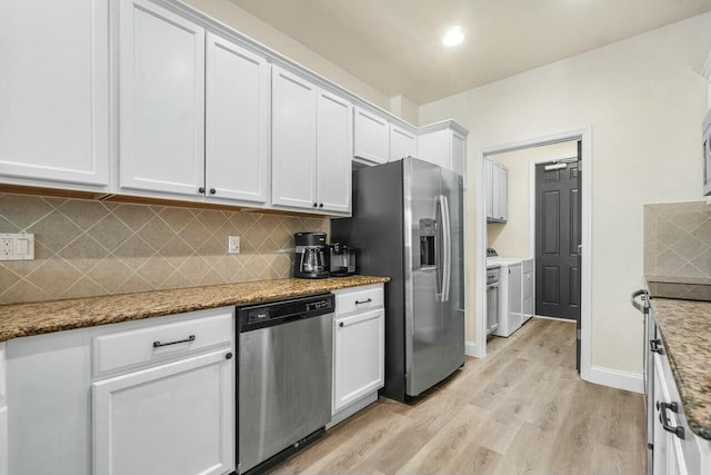 kitchen with light wood-type flooring, independent washer and dryer, backsplash, appliances with stainless steel finishes, and white cabinets