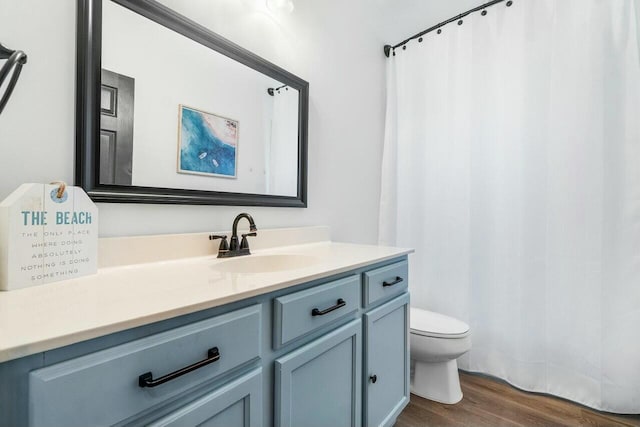 full bath featuring a shower with curtain, toilet, wood finished floors, and vanity