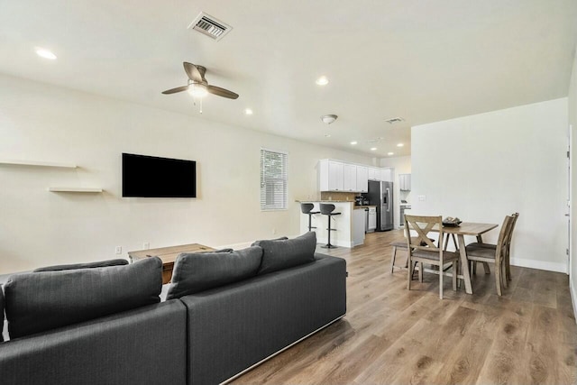 living area featuring light wood finished floors, visible vents, recessed lighting, and a ceiling fan