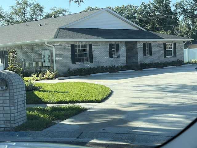 view of front of property with brick siding and roof with shingles