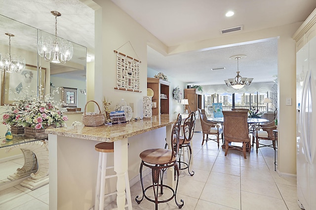 kitchen featuring a chandelier, light tile patterned floors, visible vents, and a healthy amount of sunlight