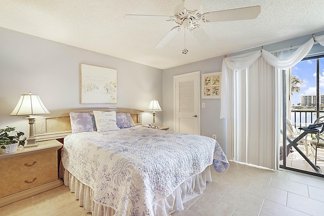 bedroom with access to exterior, light tile patterned flooring, ceiling fan, and a textured ceiling