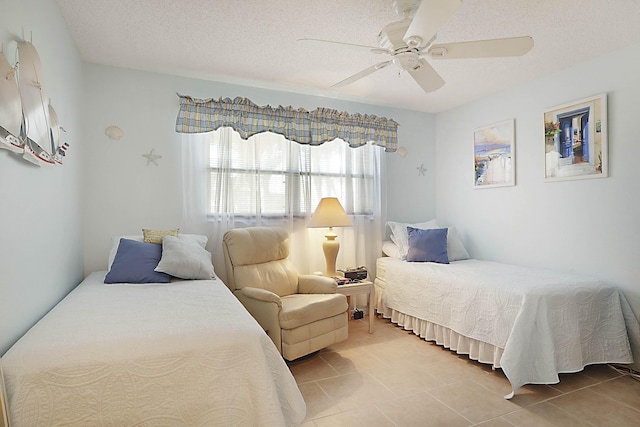 bedroom featuring a textured ceiling, ceiling fan, and light tile patterned flooring