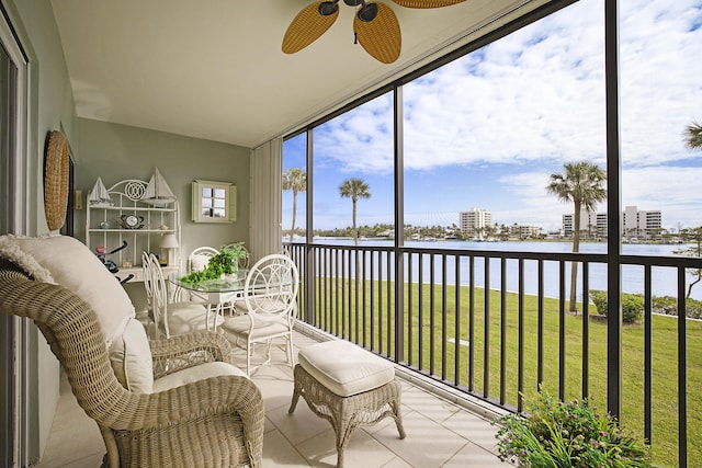 sunroom / solarium with a water view, a ceiling fan, and a healthy amount of sunlight