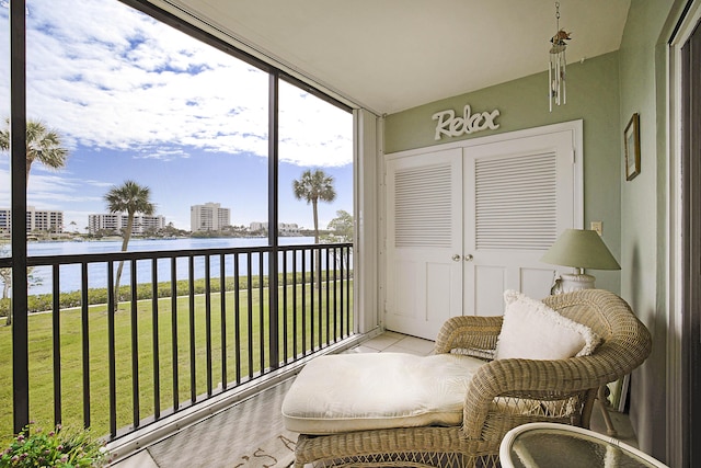 sunroom featuring a water view