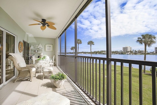 sunroom / solarium with a water view and ceiling fan