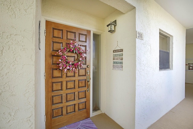 view of exterior entry featuring stucco siding