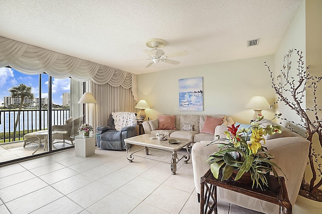 living room featuring ceiling fan, a textured ceiling, tile patterned flooring, and visible vents