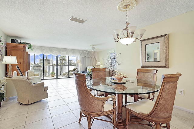 dining area with light tile patterned floors, a textured ceiling, visible vents, and a notable chandelier