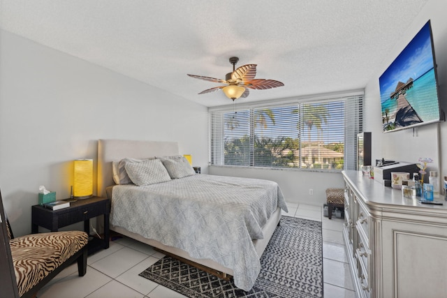 bedroom with ceiling fan, a textured ceiling, and light tile patterned floors