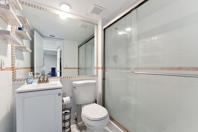 bathroom featuring a stall shower, visible vents, tile walls, and vanity