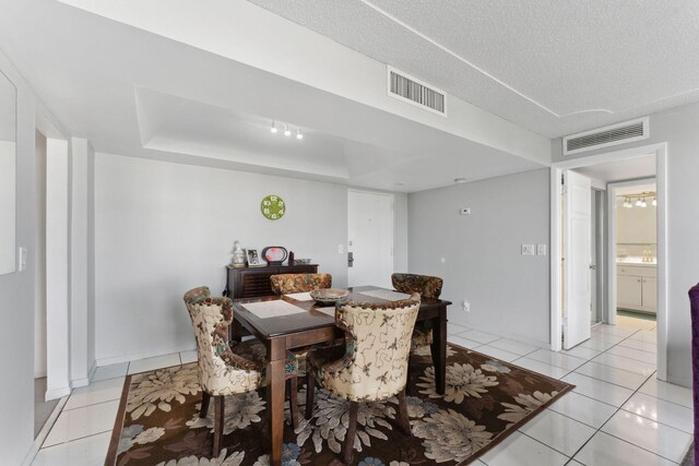 dining room with light tile patterned floors, a textured ceiling, and visible vents