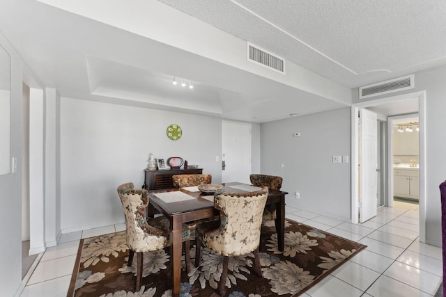 dining room featuring a textured ceiling, light tile patterned flooring, and visible vents