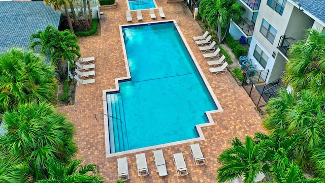 pool with a patio area and fence