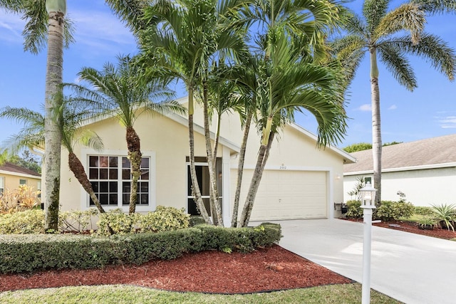 ranch-style home with a garage, concrete driveway, and stucco siding