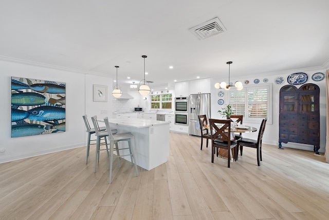 kitchen with white cabinets, visible vents, stainless steel appliances, and crown molding