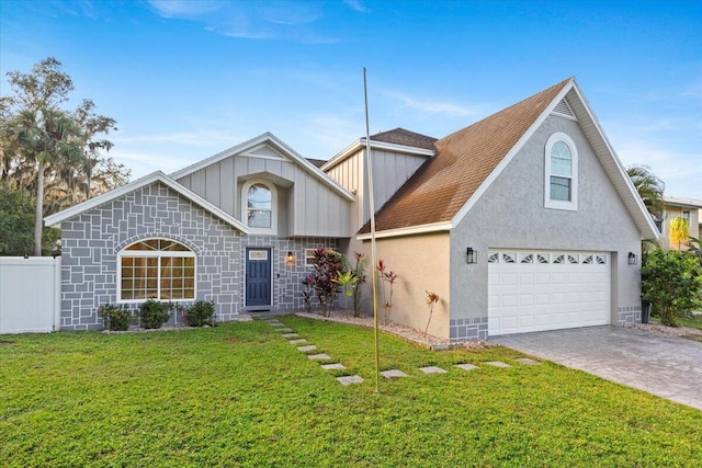 view of front of house with decorative driveway, board and batten siding, a front yard, fence, and a garage