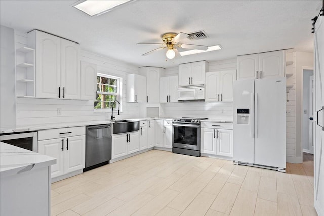 kitchen with white appliances, visible vents, ceiling fan, open shelves, and a sink