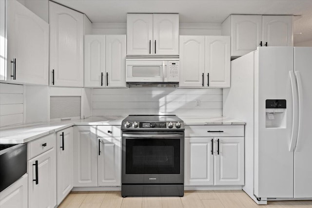 kitchen with white appliances, tasteful backsplash, light stone counters, and white cabinets