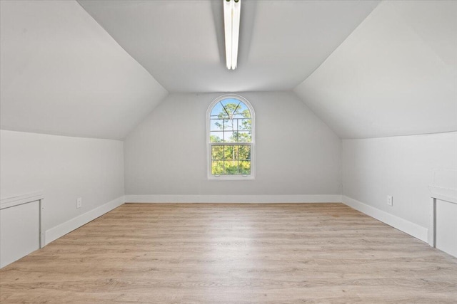 bonus room featuring baseboards, vaulted ceiling, and wood finished floors