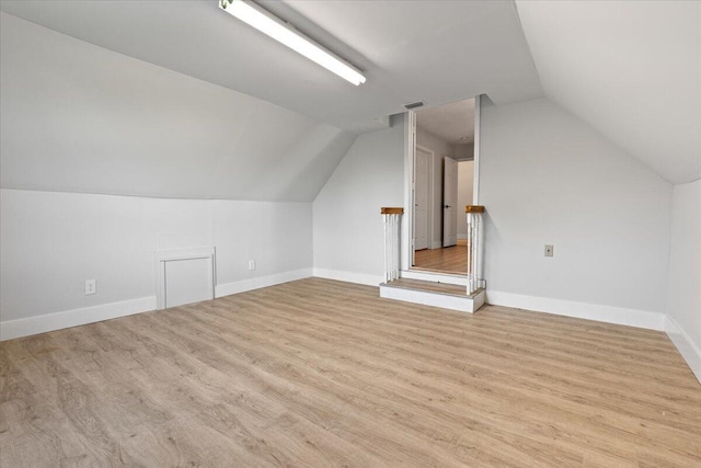 bonus room with visible vents, vaulted ceiling, baseboards, and wood finished floors