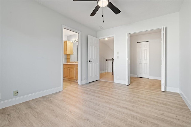 unfurnished bedroom with light wood-style flooring, connected bathroom, a sink, ceiling fan, and baseboards