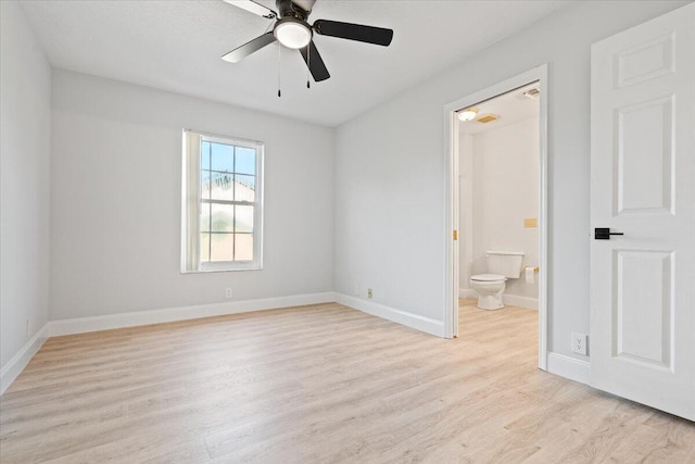 unfurnished bedroom with a ceiling fan, baseboards, ensuite bath, and light wood finished floors