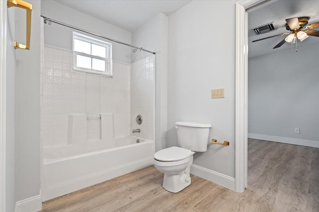 full bathroom featuring toilet, a textured ceiling, wood finished floors, and visible vents