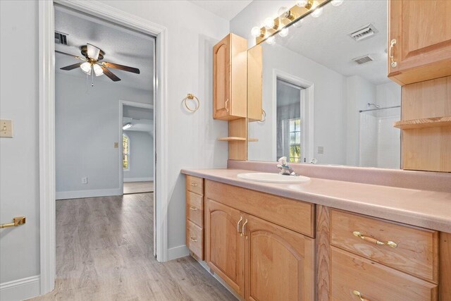 full bathroom with vanity, visible vents, a textured ceiling, and wood finished floors