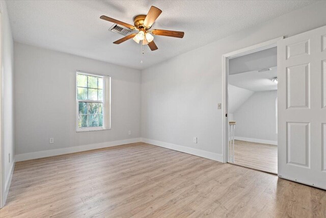 unfurnished room featuring a ceiling fan, light wood-type flooring, a textured ceiling, and baseboards