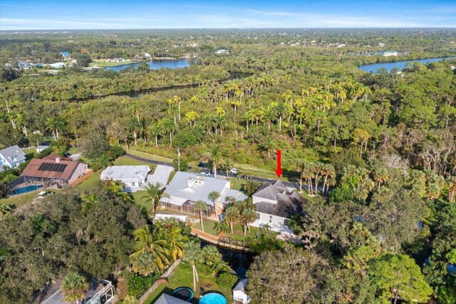 drone / aerial view featuring a water view, a residential view, and a wooded view