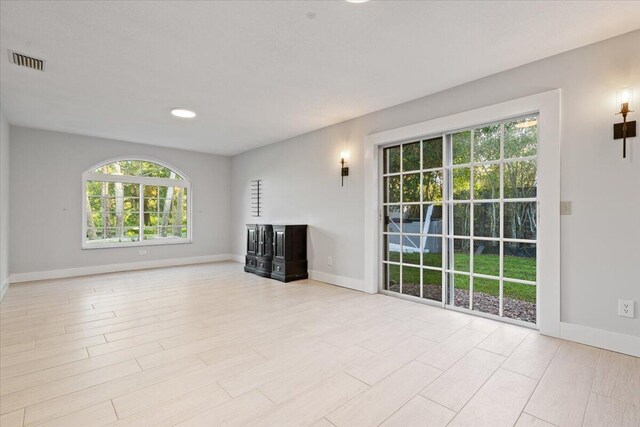 unfurnished living room with visible vents and baseboards