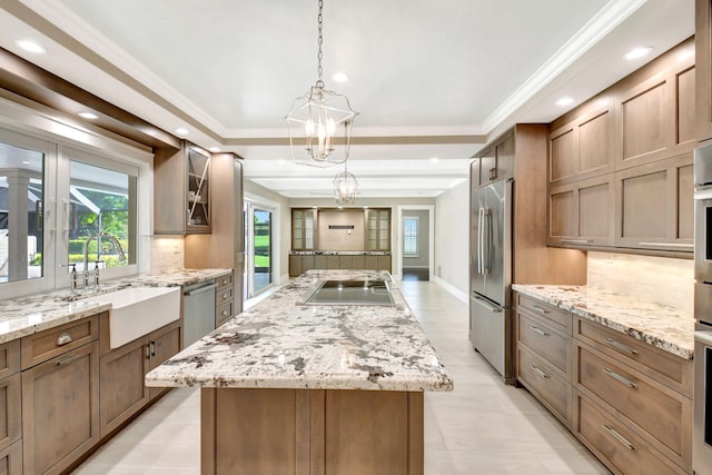 kitchen with appliances with stainless steel finishes, ornamental molding, a center island, a sink, and backsplash