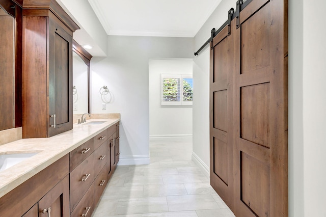 bathroom featuring a sink, baseboards, ornamental molding, tile patterned floors, and double vanity