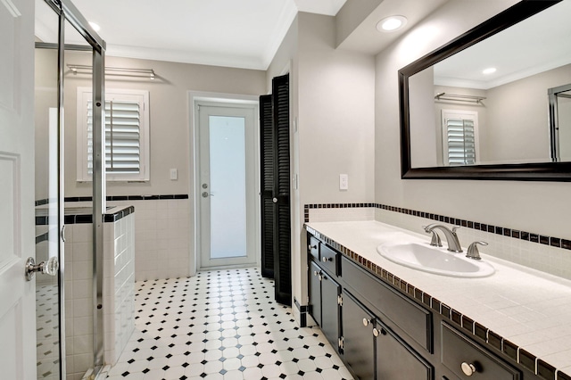 full bath featuring a wainscoted wall, tile walls, recessed lighting, ornamental molding, and vanity