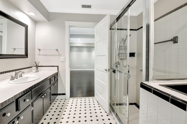 full bathroom with a stall shower, visible vents, crown molding, and vanity