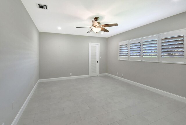 empty room featuring visible vents, ceiling fan, and baseboards