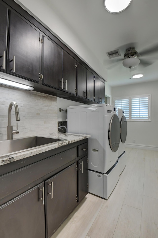 laundry area with separate washer and dryer, a sink, visible vents, a ceiling fan, and cabinet space