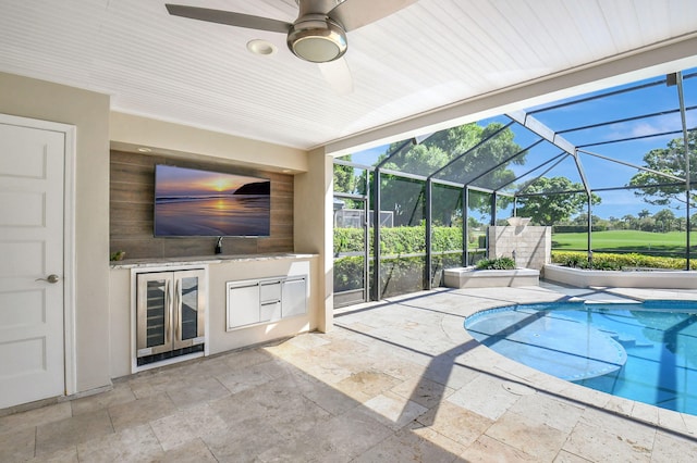 outdoor pool featuring ceiling fan, a patio, an outdoor kitchen, and glass enclosure