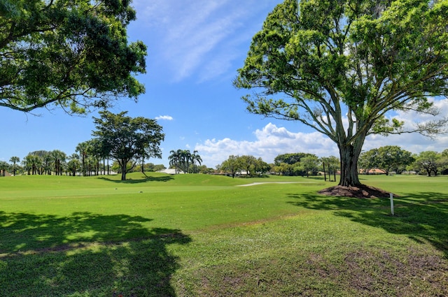 surrounding community featuring a lawn and golf course view