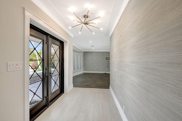 doorway to outside featuring wallpapered walls, baseboards, wood finished floors, french doors, and a chandelier