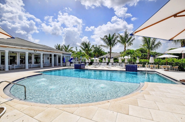 community pool with a patio and fence