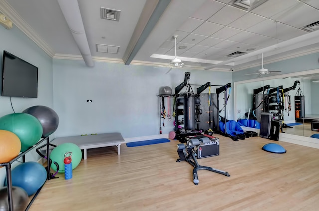 exercise room with crown molding, visible vents, ceiling fan, and wood finished floors