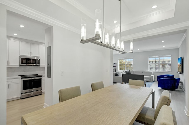 dining space with a notable chandelier, recessed lighting, light wood-type flooring, and crown molding