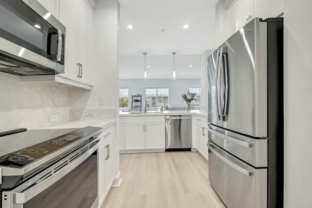 kitchen featuring recessed lighting, light wood-style floors, white cabinets, appliances with stainless steel finishes, and tasteful backsplash