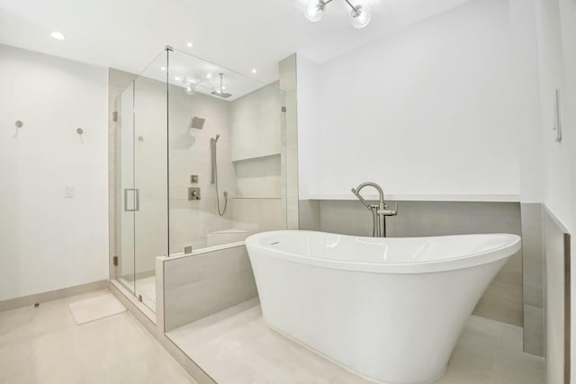 bathroom featuring recessed lighting, a stall shower, tile patterned flooring, a freestanding tub, and baseboards