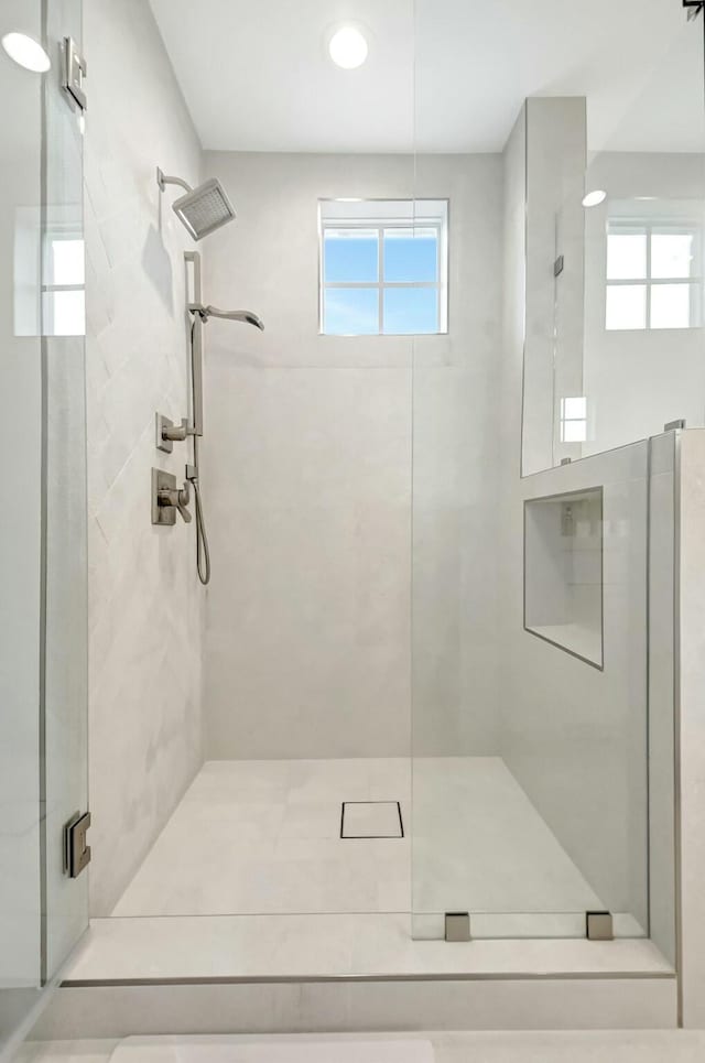 bathroom with a shower stall and a wealth of natural light